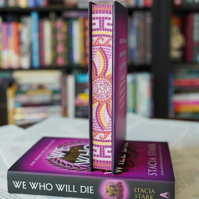 We Who Will Die LitJoy Edition spine detail — ornate mosaic tile pattern in pink, purple, orange, and gold, standing upright on standard purple edition, from LitJoy Winter Romantasy TBR Box by Stacia Stark
