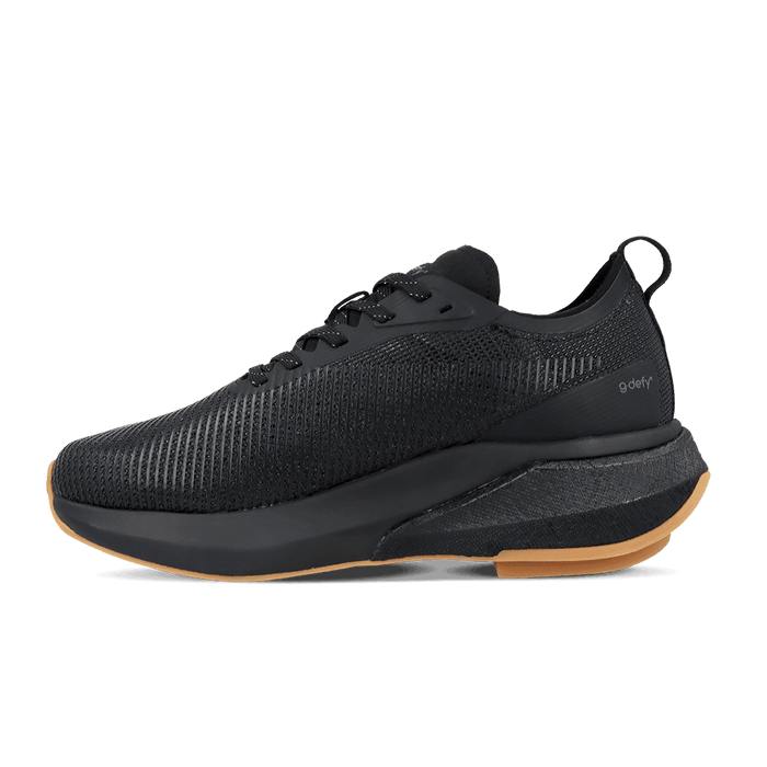 Black running shoe with a textured mesh upper, thick black midsole, and gum rubber outsole. "g-defy" logo on the side.