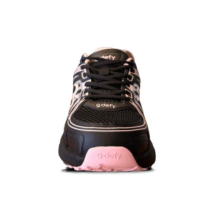g-defy athletic shoe in black with mesh upper, black laces, and pink accents on the sole and trim, front view.