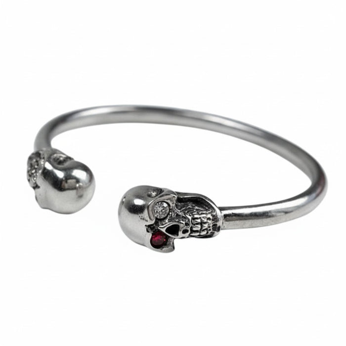 An angled view of the gothic skull cuff bracelet, showing the detailed skulls and polished silver band.