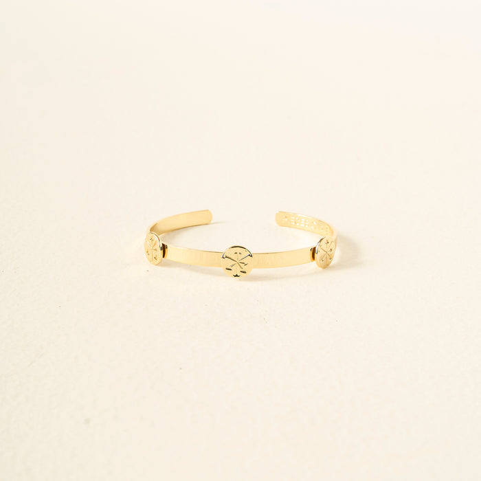 The Darling Effect’s You Are Hard-Working Skinny Stacker Bracelet is a 14k gold-plated adjustable cuff with three engraved discs, shown against a light cream background.